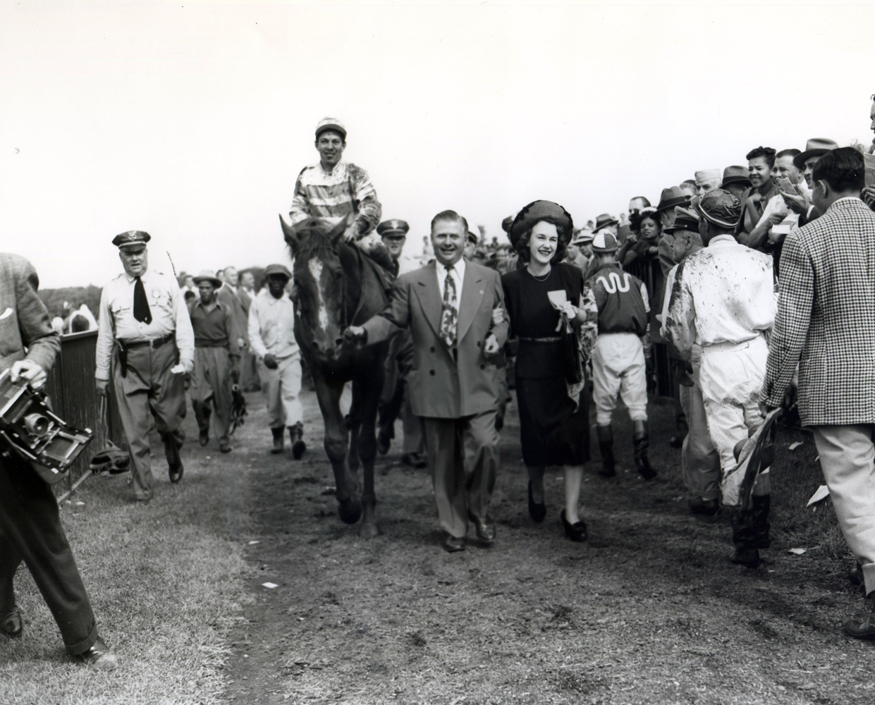 Stymie (Conn McCreary up) being led into the winner's circle by trainer Hirsch Jacobs and owner Ethel Jacobs for the International Gold Cup at Belmont (Keeneland Library Morgan Collection/Museum Collection)
