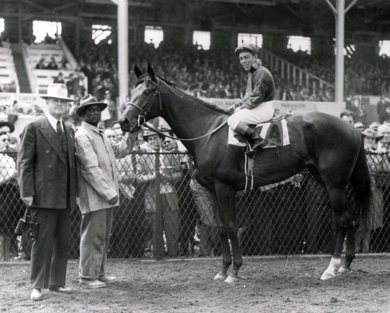 Conn McCreary and Twlight Tear in the winner's circle with trainer Ben Jones after winning the 1944 Rennert Handicap at Pimlico (The BloodHorse/Museum Collection)