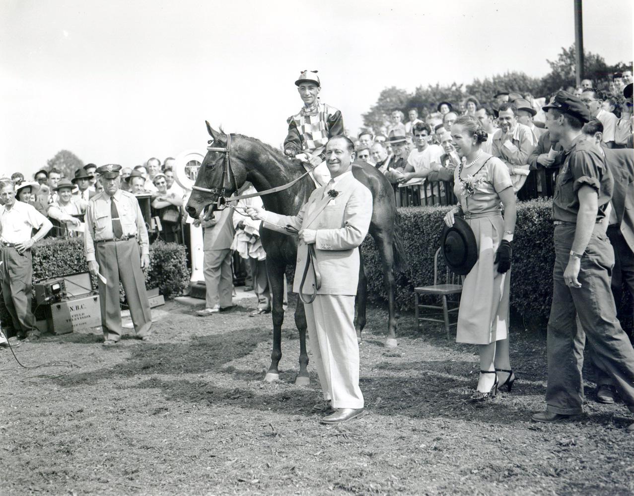 Horatio Luro holding How (Eddie Arcaro up) in the winner's circle for the 1951 Coaching Club American Oaks at Belmont Park (Keeneland Library Morgan Collection/Museum Collection)